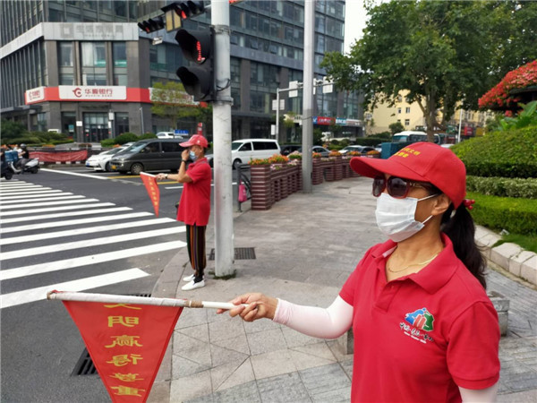 青岛市北区敦化路街道公共文明引导志愿者为创城添光彩